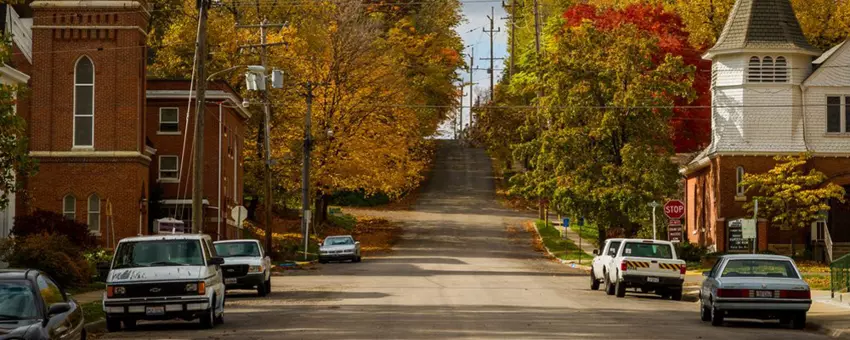 Residential street in the fall with cars and trees